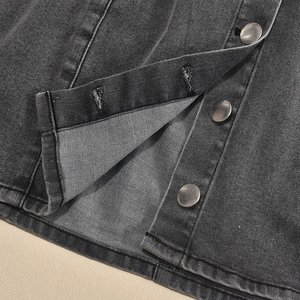Macro detail of silver buttons and washed denim fabric on a bodycon mini dress