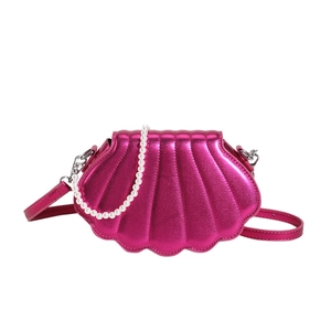 Metallic rose pink shell-shaped crossbody bag featuring pearl chain and leather strap