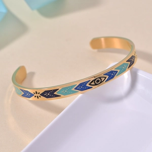 Golden Evil Eye cuff bracelet with enamel patterns and bohemian turquoise accents