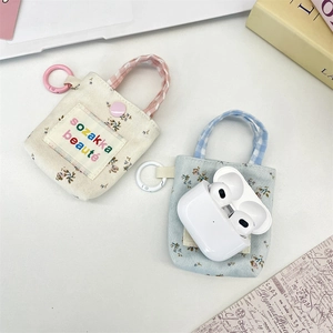 Detailed view of floral canvas earbud pouches in beige and blue with checkered handles
