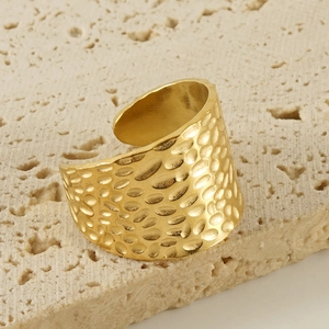 Adjustable gold hammered ring in vintage stainless steel on a natural stone background