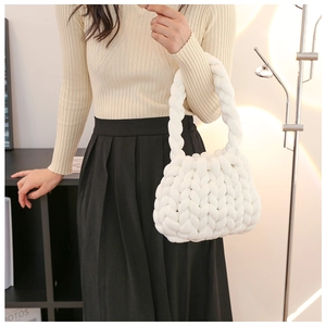 Detailed texture of white chunky knit handmade tote bag carried by a model