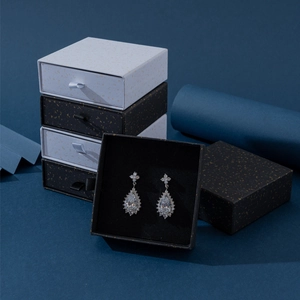 Dettaglio di orecchini in zircone d'argento in scatole per gioielli a cassetto bianche e nere
