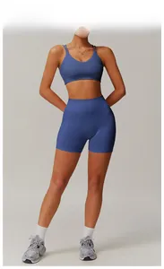 Detail of high-waisted seamless yoga shorts and strappy sports bra in deep blue finish