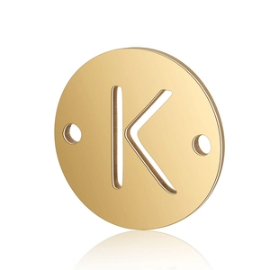 Detailed macro shot of a gold stainless steel circular pendant with a cutout letter K