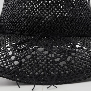 Detailed close-up of breathable black straw sun hat with woven mesh and bow tie detail