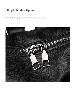 Detail shot of the dual silver metal zippers on black soft leather travel backpack