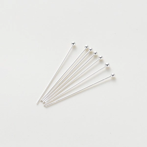 Detailed view of eight shiny silver ball head pins for DIY jewelry making and beading