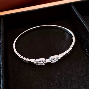 Detail of silver chain link bracelet with pave cubic zirconia in a black velvet box