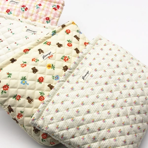 Detailed macro of assorted quilted cotton bags with floral and cartoon bear patterns