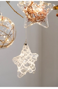 Close-up of glowing glass Christmas ornaments with warm LED lights and star patterns