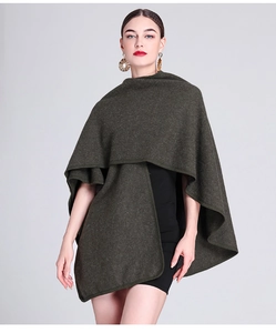 Detail of dark green knit shawl cape worn over a black dress for autumn winter fashion