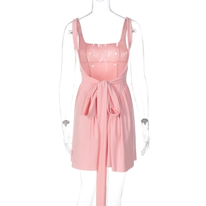 Detail view of the pink backless dress featuring a large decorative bow tie on the back