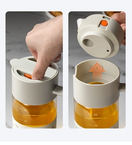 Detail of 550ml glass oil bottle showing the push-button mechanism for easy lid removal