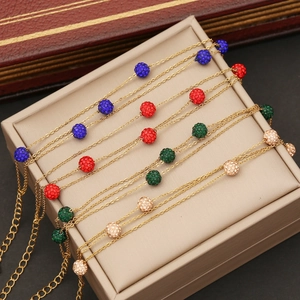 Dettaglio di bracciali con perle in argilla e cristalli su portagioie con catene dorate