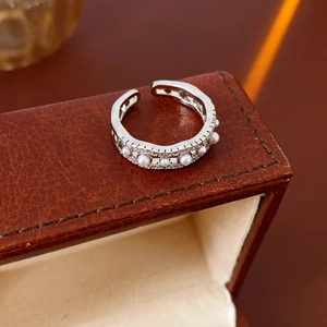 Macro view of adjustable silver ring with white pearls and sparkling zircon pavé detail