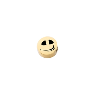 Macro shot of golden stainless steel bead with Jack Skellington smile face engraving