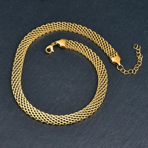 Dettaglio di un'ampia collana a maglia intrecciata dorata con chiusura a moschettone