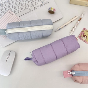 Detailed close-up of quilted down-texture pencil cases in pastel blue and purple colors
