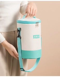 Detail of cylindrical insulated lunch bag with adjustable shoulder strap and Tasty Food label