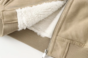 Detailed close-up of khaki suede jacket fabric with white faux shearling lining and metal zipper