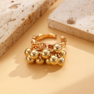 Detail of vintage textured gold alloy ring featuring small hanging spherical bell charms
