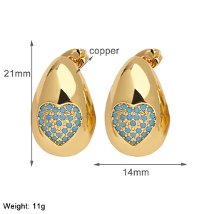 Macro view of gold plated teardrop heart earrings with blue cubic zirconia details
