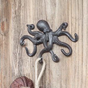 Retro Oktopus Wandhaken aus Gusseisen mit mehreren Armen auf rustikalem Holzhintergrund