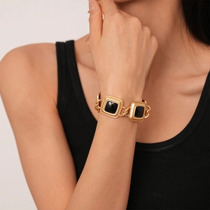 Close-up of vintage gold chunky chain necklace with black enamel square pendants on neck