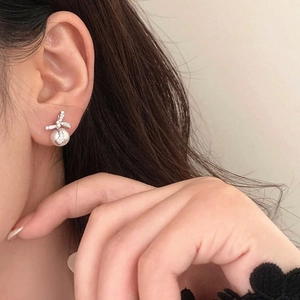 Elegant silver bow earrings with zircon and pearl shown on model for a stylish look