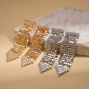 Boucles d'oreilles pompons dorées 18 carats avec paillettes et zircons sur marbre
