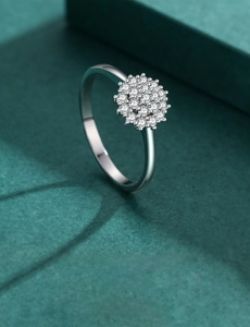 Macro shot of silver S925 ring with clustered micro-pave diamonds on a green surface
