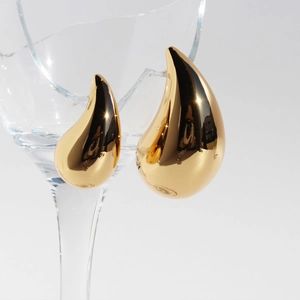 Minimalist golden teardrop earrings with a polished mirror finish in a modern metal style