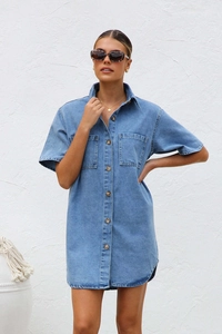Detail shot of light blue denim shirt dress featuring button-down front and chest pockets