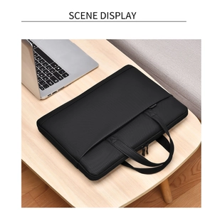 Waterproof black 14-inch laptop bag with sturdy handles on a minimalist desk
