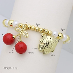 Detail of beaded bracelet with red cherry charm, golden fish pendant and pearl beads
