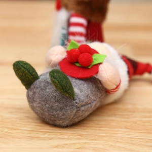 Christmas gnome doll with grey felt hat and red berry details on a wooden table surface