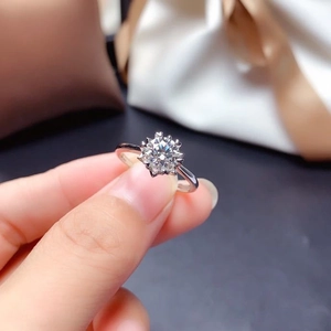 Handheld silver adjustable ring with a large brilliant-cut round moissanite in snowflake setting