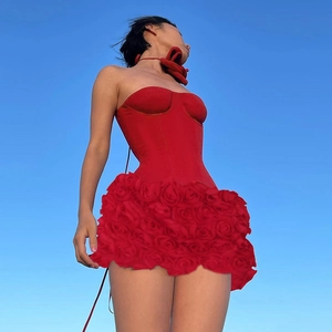 Elegantes rotes trägerloses Minikleid mit 3D-Rosenblütenstruktur vor blauem Himmelshintergrund