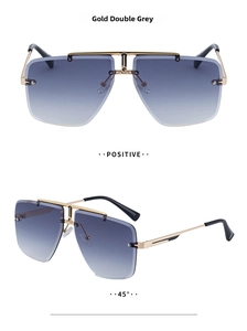 Detail view of double grey gradient lenses and gold metal accents on rimless sunglasses