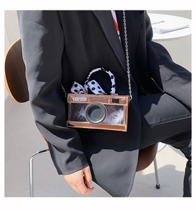 Creative rose gold camera bag with white feathers and polka dot scarf detail