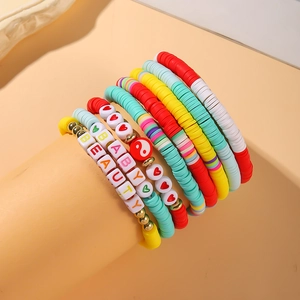 Detail shot of colorful Heishi clay bead bracelets featuring heart and letter charms