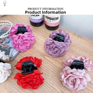 Detail of elegant large rose flower hair claws in rose red, purple, red and light pink