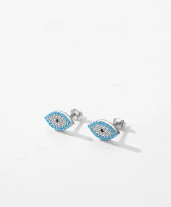 Macro shot of 925 silver evil eye stud earring with turquoise and zircon stones