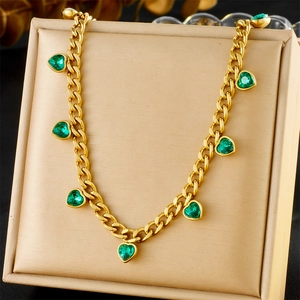 Detail of gold-plated Cuban chain necklace featuring vibrant green heart-shaped pendants