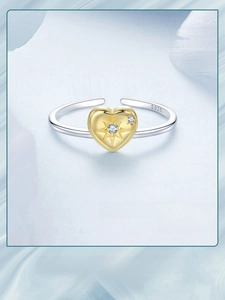 Macro detail of S925 sterling silver ring featuring a golden heart with starburst and zircon