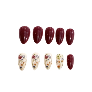 Glossy almond press-on nails with burgundy red and floral pattern design on white background