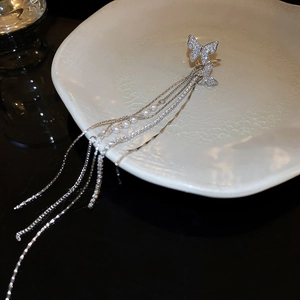 Close-up of butterfly ear cuff with sparkling tassels and delicate white pearls