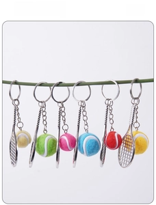 Détail de six porte-clés mini raquettes de tennis colorées sur un support de présentation