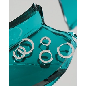 Three sizes of polished S925 sterling silver hoop earrings on a blue glass background